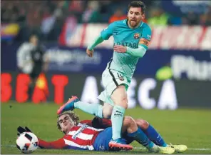  ?? JUAN MEDINA / REUTERS ?? Barcelona’s Lionel Messi steps over Atletico Madrid’s fallen Antoine Griezmann during their Spanish King’s Cup semifinal first-leg match in Madrid on Wednesday.