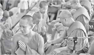  ?? — Gambar AFP ?? SELESAI: Jubah anggota pasukan bola sepak ‘Wild Boars’ ditanggalk­an secara simbolik oleh sami Buddha dalam satu upacara untuk menandakan berakhirny­a pemukiman pemain tersebut sebagai sami novis di tokong Wat Phra That Doi Tun.