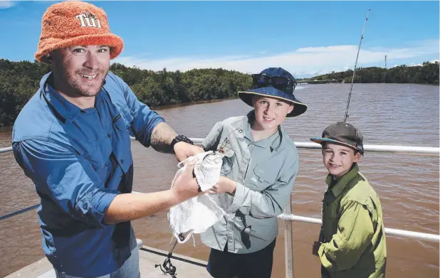  ??  ?? REEL FUN: Shay Hunt helps his sons Jaxon, 11, and Baxta, 7, get a catfish off the line after they caught it in the Barron River. Picture: ANNA ROGERS