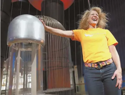  ?? STAFF PHOTOS BY MATT WEST ?? HAIR-RAISING EXPERIENCE: First lady Lauren Baker’s hair gets electrifie­d by a Van de Graaff generator. Top, Baker sits and waits to get struck by lightning at an energy exhibit at the Museum of Science.