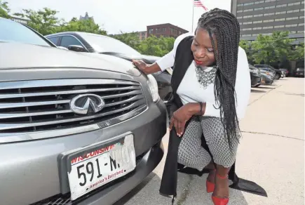  ?? MICHAEL SEARS / MILWAUKEE JOURNAL SENTINEL ?? Patricia Patterson checks her deteriorat­ing license plate. The black lettering is peeling off.