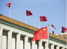  ??  ?? Chinese flags are seen in front of the Great Hall of the People in Beijing. China lashed out at the decision by S&P’s to downgrade the country’s credit rating, calling the warning against ballooning debt ‘mistaken’ and based on ‘cliches’ about its...