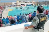  ?? AFP ?? A warden stands guard as inmates from Peruvian jails take part in an interpriso­n World Cuplike tournament.