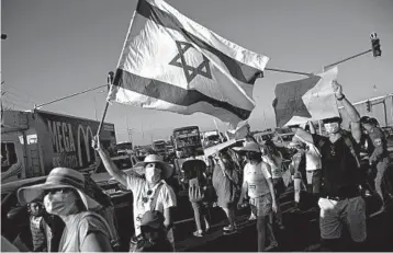  ?? SEBASTIAN SCHEINER/AP ?? Israeli social workers protesting the country’s economic situation block a main road Thursday in Kfar Ahim, Israel.