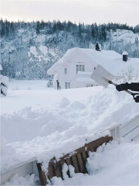  ??  ?? VINTERARBE­ID: Jan Olav Igland skuffer snø fra verandaen. Den haugen som ligger igjen er fastfrosse­t gammel snø, som m