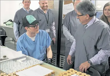  ?? JOHN LOVE / SENTINEL & ENTERPRISE ?? Fitchburg Mayor Stephen DiNatale chats with Dustin Aldrich-Hunt in the extraction room at Revolution­ary Clinics — a marijuana cultivatio­n center in a repurposed mill building — about his work during a tour of the facility Wednesday.