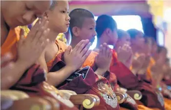  ?? LILLIAN SUWANRUMPH­A/GETTY-AFP ?? The boys mark the end of a retreat as novice monks Aug. 4, 2018, after honoring a diver who died trying to save them.