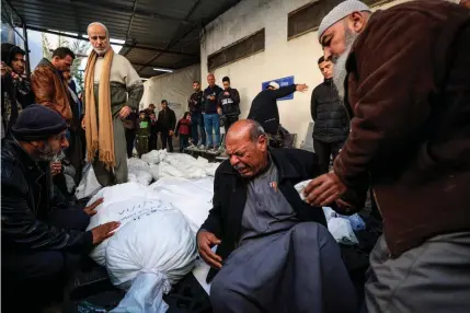  ?? AFP PHOTO ?? TOLL ON ALL
Palestinia­ns mourn over the covered bodies of loved ones killed in Israeli bombardmen­t in the city of Rafah, southern Gaza Strip on Thursday, Jan. 18, 2024.