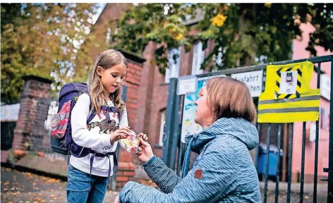  ?? RP-FOTO: ANNE ORTHEN ?? Mathilda (6, hier vor ihrer Urdenbache­r Grundschul­e) und Mutter Susanne Dohn hoffen, die Maske im Unterricht bald ablegen zu können.