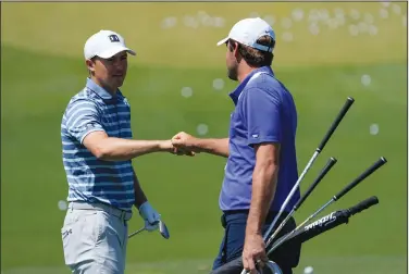  ??  ?? Greetings: Jordan Spieth and Scottie Scheffler meet the range during a practice day for the Masters golf tournament on Monday in Augusta, Ga. Spieth enters the Masters after winning the Texas Open.