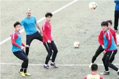  ?? — AFP photo ?? This picture taken on April 12, 2017 shows Beijing Institute of Technology’s Spanish head coach Roberto Ahufinger del Pino (2nd L) taking part in a football training session with his players in Beijing.
