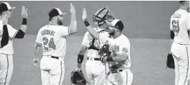  ?? TERRANCE WILLIAMS/AP ?? The Orioles congratula­te one another after defeating the Los Angeles Angels 10-6 on Wednesday night at Camden Yards, ending the longest losing streak in Major League Baseball since 2005 at 19 games.