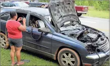  ?? Spencer Lahr / Rome News-Tribune ?? Sabrina Williams takes a picture of her Chrysler Pacifica that caught fire on Thursday. Williams was in the vehicle with her 9-year-old daughter Azirra Williams when the fire started but they were both able to make it out safely.