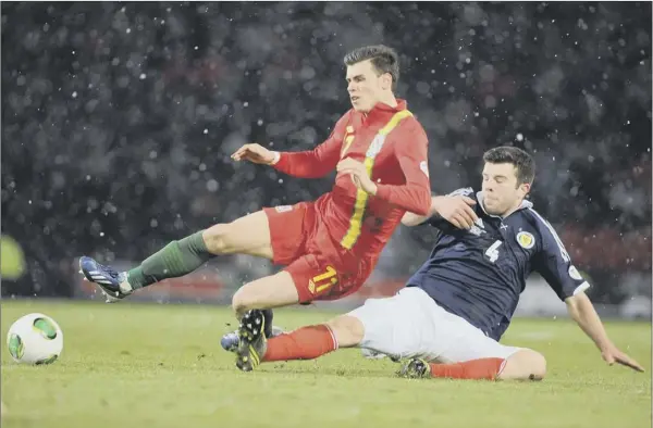  ?? Picture: Ian Rutherford ?? Gareth Bale is felled by Scotland goalscorer Grant hanley during the Spurs superstar’s curtailed 45-minute stint at hampden last night