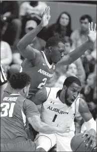  ?? AP/BRYAN ANDERSON ?? Auburn’s KT Harrell (1) tries to dribble away from double-team pressure by Arkansas’ Alandise Harris (top) and Anton Beard during the Razorbacks’ 101-87 victory Tuesday night in Auburn, Ala.