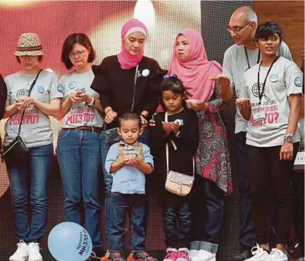  ?? PIC BY SALHANI IBRAHIM ?? Intan Maizura Othman (fourth from right) with her children and kin of Flight MH370 passengers and crew at a remembranc­e gathering in Kuala Lumpur yesterday.