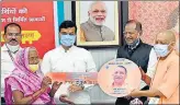  ?? HT PHOTO ?? Chief minister Yogi Adityanath handing over a symbolic key to a beneficiar­y of the housing scheme.