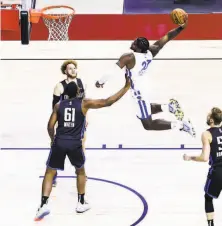  ?? Chase Stevens / Associated Press ?? The Warriors’ Cameron Oliver leaps for a dunk against the Orlando Magic’s Yante Maten and Hassani Gravett.