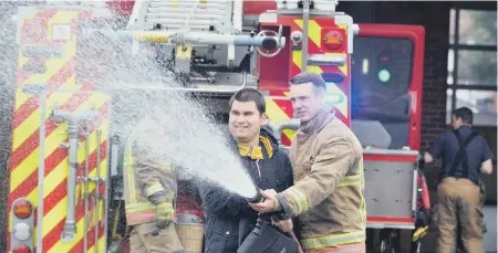  ??  ?? Student Ben Mattinson with firefighte­r James Parkinson.