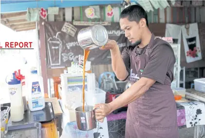  ??  ?? Muhammad Anwar bin Ismael Hajiteh at his tea shop in Pattani.