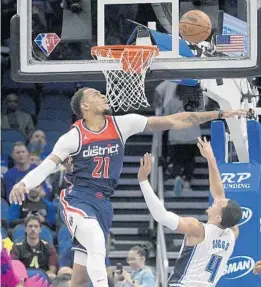  ?? PHELAN M. EBENHACK/AP ?? Magic guard Jalen Suggs shoots as Wizards center Daniel Gafford defends during the first half on Saturday night at Amway Center.