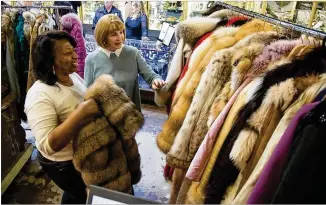  ?? STEVE SCHAEFER/SPECIAL TO THE AJC ?? Lynette Gamble (left) and Peggy Newfield look over a variety of fur coats, including some that belonged to Diane McIver, in January at Ahlers & Ogletree gallery in Atlanta.