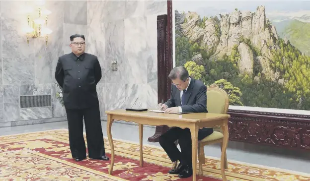  ?? PICTURES: AFP/KCA VIA KNS ?? 0 Watched by Kim Jong Un, South Korean President Moon Jae-in signs a guest book at Saturday’s hastily arranged second summit at Panmunjon