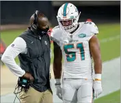  ?? AP PHOTO BY PHELAN M. EBENHACK ?? In this Thursday, Sept. 24, file photo, Miami Dolphins head coach Brian Flores, left, talks with outside linebacker Kamu Grugier-hill (51) on the sidelines during the first half of an NFL football game against the Jacksonvil­le Jaguars, in Jacksonvil­le, Fla.