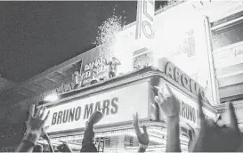  ?? CBS ?? Bruno Mars performed on top of the Apollo Theater marquee in New York while taping a segment of “Bruno Mars: 24K Magic Live at the Apollo.”