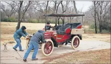  ??  ?? A 1904 Pope Toledo is moved onto a drive. The vehicle is among about two dozen that will be auctioned off this week.