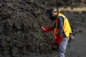  ?? Emilio Morenatti, The Associated Press ?? A scientist with the Canary Islands' volcanolog­y institute, Involcan, measures the temperatur­e of a lava flow on Oct. 30.