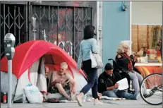  ?? RAY CHAVEZ/BAY AREA NEWS GROUP FILE PHOTOGRAPH ?? A pedestrian walks by a small homeless encampment on Howard Street in San Francisco on Nov. 1, 2018.