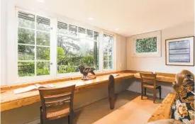  ??  ?? Multi-panel windows and three walls welcome natural light into the sun room of the trilevel home. Custom shelving creates a U-shaped desk along three walls in the office where Alice Walker frequently worked.