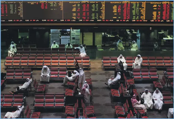  ?? AFP ?? Traders follow the market at the Kuwait Stock Exchange yesterday. Kuwait stocks slip,