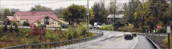  ?? Lori Van Buren / Times Union archive ?? From Rt. 30, the Apple Barrel Country Store is seen on the left of the new memorial for the limousine crash victims on Oct. 3, 2019 in Schoharie. The owner of Apple Barrel sent a letter to the state DOT years prior to the crash to warn them of the dangers of the road near his store.