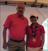  ?? PHOTO COURTESY WEST CHESTER EAST ?? West Chester East coach Todd Lorback hangs a gold medal around the neck of Victoria Kim on Tuesday after she won the PIAA Class 3A individual golf championsh­ip at Heritage Hills in York.