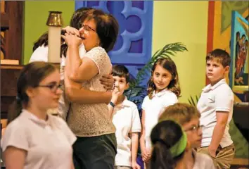  ?? Darrell Sapp/Post-Gazette photos ?? Diann Ranallo, first-grade teacher at St. Ursula School, tears up as several students made a presentati­on at the awards ceremony after Mass on Friday on the last day of school for St. Ursula School in Hampton.