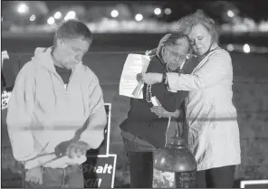  ?? Arkansas Democrat-Gazette/STATON BREIDENTHA­L ?? Anti-death penalty activist Randy Gardner (left) rings a bell as Judy Robinson-Johnson and Kim Antoine embrace Thursday night at Cummins prison during the execution of Kenneth Williams.