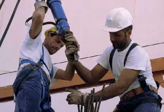  ?? (foto Imagoecono­mica) ?? Un cantiere Due operai al lavoro nella costruzion­e di un palazzo