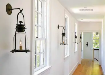  ??  ?? The upstairs hallway is lined with hanging hurricane lanterns from Lars Bolander.