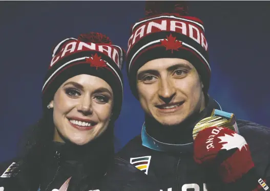  ?? CHARLIE RIEDEL/ THE CANADIAN PRESS/ FILES ?? Ice dancers Tessa Virtue and Scott Moir show off their gold medal at the 2018 Winter Olympics in Pyeongchan­g, South Korea.