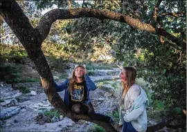  ?? TAMIR KALIFA / AMERICAN-STATESMAN ?? Marisela Sandoval, 11, and Ceil Raia, 11, climb a tree near the Zilker Hillside Theater recently as they wait for the start of “The Wizard of Oz,” presented by Zilker Theater Production­s.