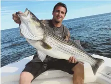  ?? COURTESY PHOTO ?? A REEL GOOD CATCH: Fan Favorite photo contest winner Brian Dalena shows off the 45-inch striper which helped him win a new Van Staal spinning reel. Go to www.stripercup.com to find out how you could be the next winner.