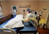  ?? GERALD HERBERT/ASSOCIATED PRESS ?? Medical staff move a COVID-19 patient who died onto a gurney to hand off to a funeral home van Wednesday at the Willis-Knighton Medical Center in Shreveport, La.