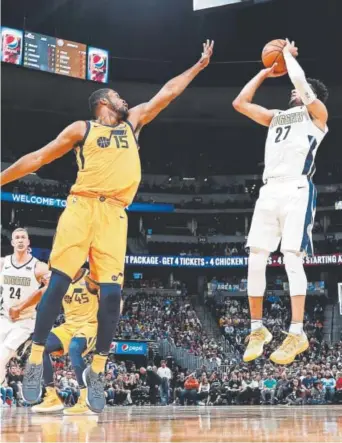  ?? David Zalubowski, The Associated Press ?? Nuggets guard Jamal Murray gets off a shot against the efforts of Utah Jazz forward Derrick Favors on Tuesday night at the Pepsi Center. Murray scored 22 points.