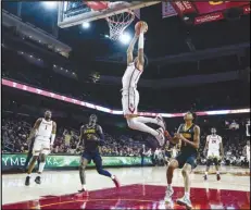  ?? Associated Press ?? Southern California guard Boogie Ellis (center) dunks against California during the first half of an NCAA college basketball game on Wednesday in Los Angeles.