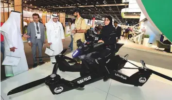  ?? Atiq Ur Rehman/Gulf News ?? Roqayya Abdul Latif, a Dubai Police cadet, demonstrat­es the Hoverbike S3 2019 Serial 001 at the Dubai Police stand during Gitex Technology Week 2018.