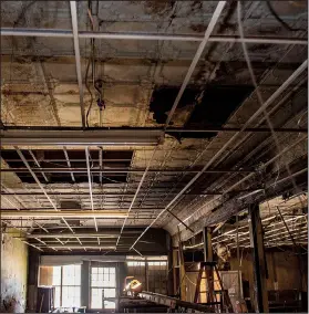  ??  ?? Colorfully painted woodwork and tin ceiling tiles above what was the entrance to the Harlem Theater