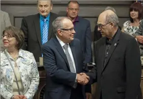  ?? Jessie Wardarski/Post-Gazette ?? HAPPY TRAILS Darlene Reardon of Wilkins, left, stands next to her husband, James Reardon, center, as he shakes hands with Nicholas W. Futules, Allegheny County Council vice president, right, as Mr. Reardon is honored Wednesday for his longtime service as facilities management director in the county at the Allegheny County Courthouse, Downtown. Mr. Reardon will officially retire on May 31.