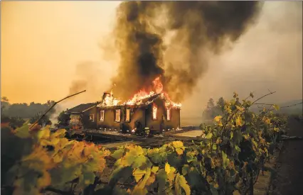  ?? Noah Berger / Associated Press ?? Vines surround a burning building as the Kincade Fire burns through the Jimtown community of unincorpor­ated Sonoma County, Calif., on Thursday.